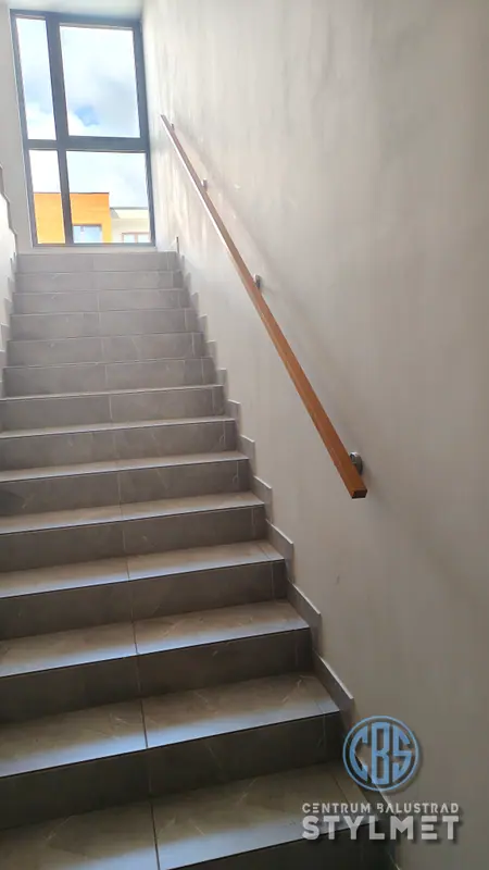 Poręcz ścienna z drewnianym pochwytem nad schodami