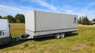 Przyczepa 2700 kg z plandeką, widok od strony dyszla z kołem zapasowym