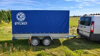 Przyczepa lekka 750 kg z niebieską plandeką w widoku z boku