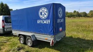 Tył przyczepy lekkiej 750 kg — dwie osie, oświetlenie i plandeka mocowana linką